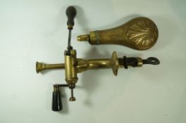 A brass cartridge loader with turned wooden handles and brass shot flask embossed with a shell