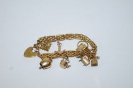 A bracelet, of gate type links, indistinctly tagged, with charms attached and a padlock clasp, 23.
