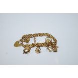 A bracelet, of gate type links, indistinctly tagged, with charms attached and a padlock clasp, 23.