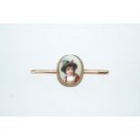 A bar brooch set with a German transfer printed image of a boy,