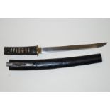 An early 20th century Japanese short sword, with a shagreen handle and wooden scabbard,