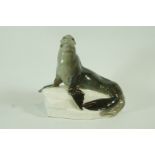 A Meissen porcelain figure of a sea lion on a rock, crossed swords mark,