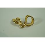 A diamond set bow brooch, stamped '750',