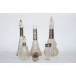 A collection of four silver mounted scent bottles; with a silver mounted glass pin box;