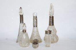 A collection of four silver mounted scent bottles; with a silver mounted glass pin box;