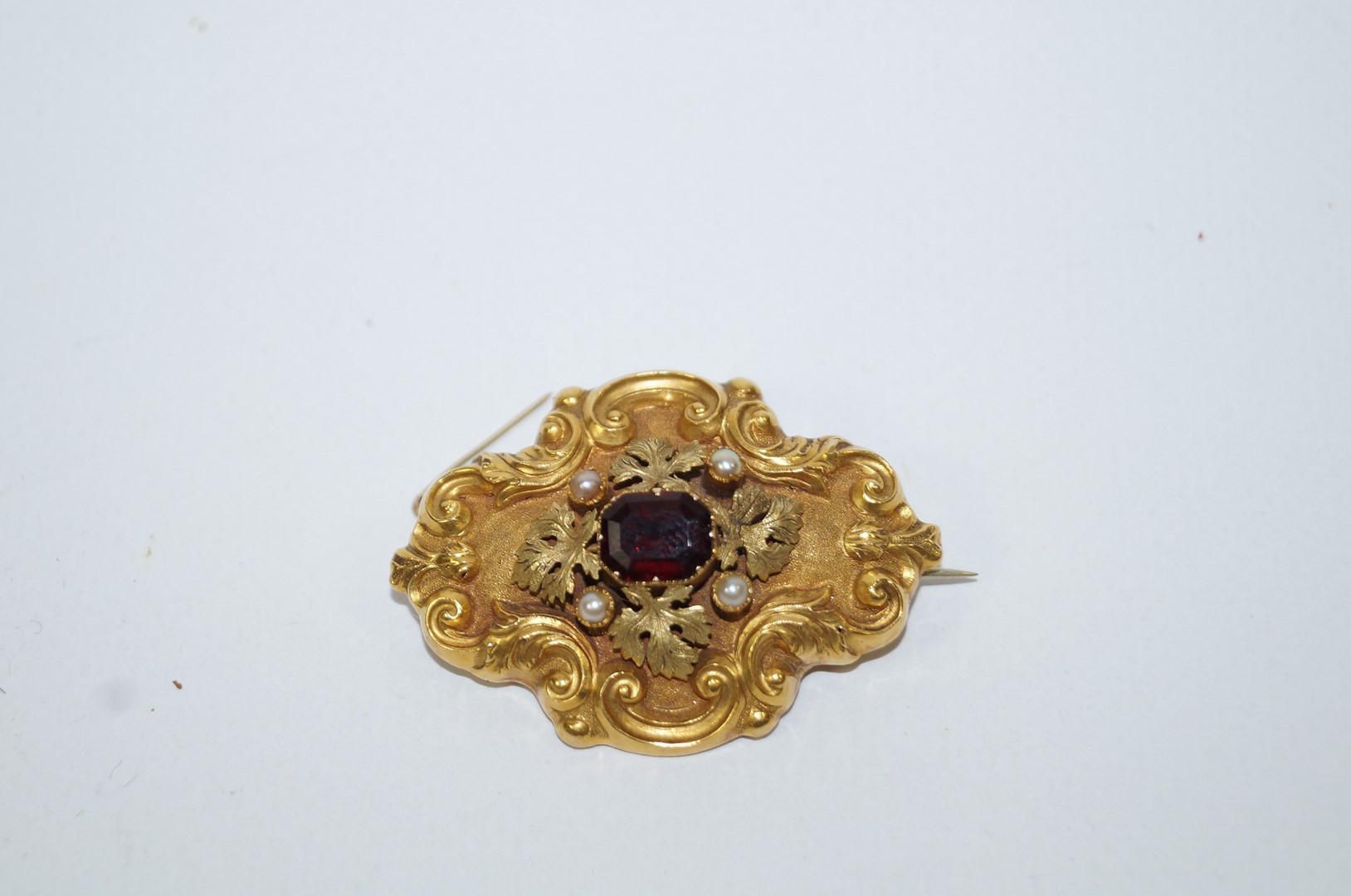 A Victorian gold, simulated pearl and garnet brooch, locket back, 4.6 cm long, 12.