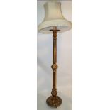 A gilded standard lamp with a round egg and dart bordered base on bun feet,