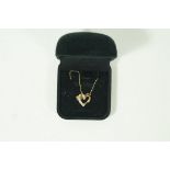 A diamond set heart pendant, stamped '375', set with five small single cuts,