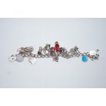 A bracelet, of solid curb links, with several charms attached,