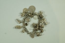 A silver bracelet, of solid curb links to a padlock clasp, with charms attached, 103.5 g (3.