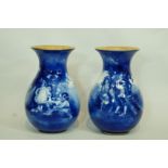 A pair of Royal Doulton "Blue Children" vases, each with flared rims with gilt interiors,