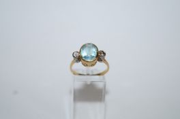 An aquamarine and diamond three stone ring, partial '18ct' stamp,