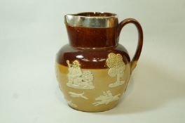 A Victorian Doulton Lambeth stoneware jug, with applied stag hunting scene and silver rim,