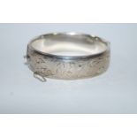 A silver hinged bangle, half engraved decoration, 1.