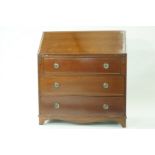 A mahogany bureau with fall front above three long drawers with shaped apron and bracket feet,