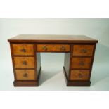 A mahogany and walnut knee hole desk with leather inset top and three drawers to either side,