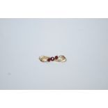 A 9 carat gold garnet brooch, Chester 1907, the trio of graduated stones to a scroll mount, 2.