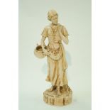 A Bretby pottery figure of a lady, holding a basket, with overall cream glaze, impressed marks,