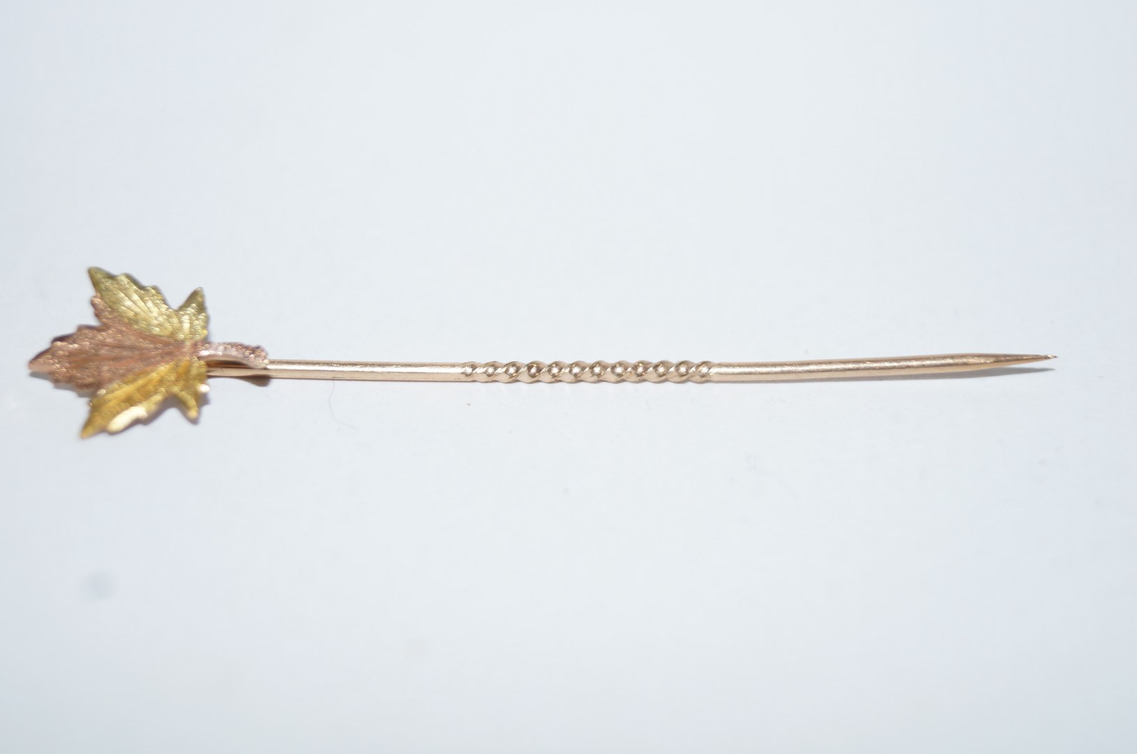 A Canadian three colour maple leaf stick pin, stamped '10K', 0.