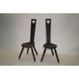 A pair of early 20th century oak Welsh stools, the back carved with a flowering branch,