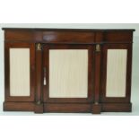 An early 19th century mahogany credenza with break front, the doors with pleated silk panels,