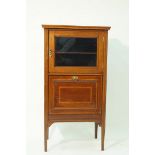 An Edwardian mahogany and boxwood strung music cabinet with one glazed door above a drop down sheet