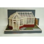 A 20th century model of a conservatory, complete with Victorian style wrought metal furniture,