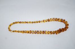 A graduated row of square outlined amber beads, 72 cm long,