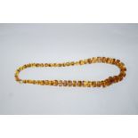 A graduated row of square outlined amber beads, 72 cm long,