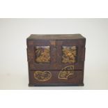 An early 20th century Japanese red lacquer table cabinet decorated with oriental motifs,