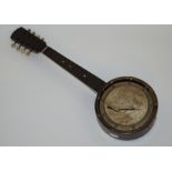 A 20th century banjo, with a mother of pearl inlay to the finger board, faux ivory pegs,