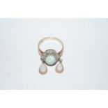 A 9ct gold opal and diamond ring, the cabochon enclosed by small single cuts, finger size N,