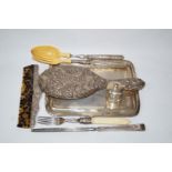A white metal dressing table tray; a hand mirror; a comb; a pepper mill;