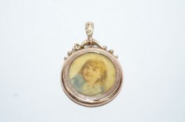 An Edwardian picture pendant, tagged '9ct', with a scroll top to the bale, 3cm diameter, 4.