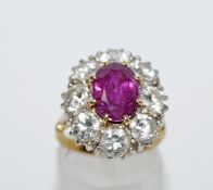 A ruby and diamond cluster ring, the oval cut measuring approximately 10mm by 7.
