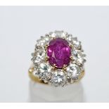 A ruby and diamond cluster ring, the oval cut measuring approximately 10mm by 7.