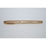 A gold Sheaffer pen in an engine turned 9 carat gold case with a 14k nib,