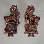 A Pair of Buddhist Lion Wall Carvings Both shown standing upon a patterned ball, one lion