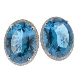 Pair of Blue Topaz, Diamond, 14k White Gold Earrings. Each centers one oval-cut blue topaz