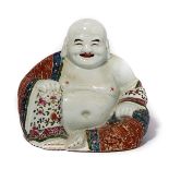 A Famille Rose Figure of Budai Modeled seated, wearing an extravagant loose fitted robe picked out