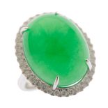 Jade, Diamond, 14k White Gold Ring.  Centering one oval jadeite cabochon measuring approximately