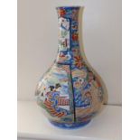 A Japanese Imari bottle vase of bulbous form decorated with panels of landscape scenes, the body