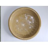 A Chinese crackle glaze earthenware dish, of brownish celadon colour, having a circle of spur