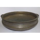 An antique Indian bronze Urli (temple bowl), having a pair of scroll handles and with inscription to