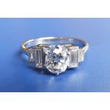 A diamond dress ring, the central claw set cushion cut diamond weighing approximately one carat