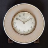 An early 20thC Cartier enamelled silver-gilt travelling clock, the circular white convex dial with