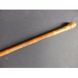 A signed Japanese bamboo walking stick carved with a carp to one side