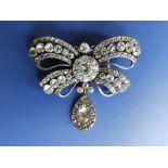 A Victorian diamond paste bow brooch with pendeloque drop, 2” across