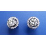 A pair of diamond stud earrings, the stones weighing 0.61 & 0.63 carat with detachable diamond