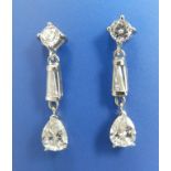 A pair of three stone diamond drop earrings in white metal, 1.1”